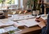 Lernunterlagen, Karte und Notizen neben vier Weingläsern und Weinflaschen auf einem Tisch
